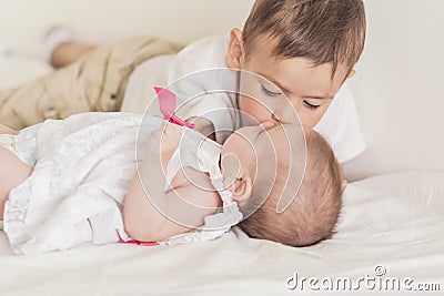 Little Caucasian Boy Kissing His Newborn Sister. Indoors Shot. Stock Photo