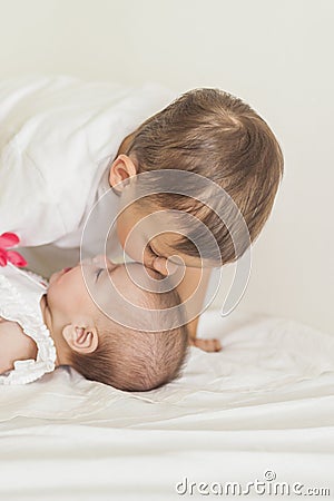 Little Caucasian Boy Kissing His Newborn Sister. Indoors Shot. Stock Photo