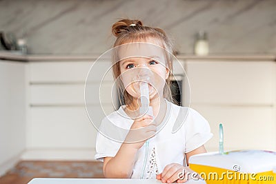 Little caucasian girl is breathing with special mask, which helps to stop asthma attack or relieve symptoms of Stock Photo