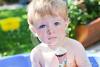 Little caucasian toddler boy eating ice cream in cone Stock Photo