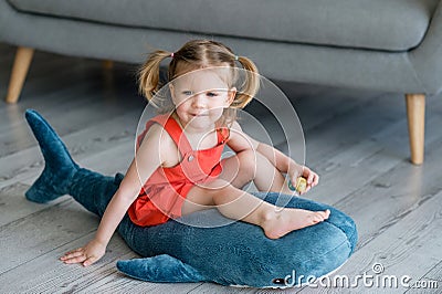 A little charming girl in a red dress is playing Stock Photo