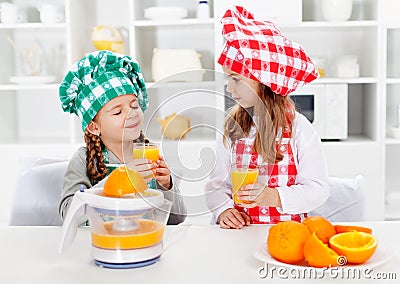 Little chef girls tasting the orange juice they made Stock Photo