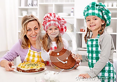 Little chef girls with their mother making a cake Stock Photo