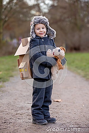 Little child, blond boy with pet dog, carying home on his back, kid, having paper house Stock Photo