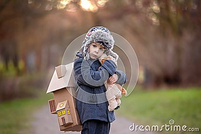 Little child, blond boy with pet dog, carying home on his back, kid, having paper house Stock Photo