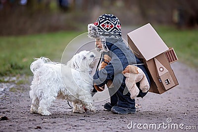 Little child, blond boy with pet dog, carying home on his back, kid, having paper house Stock Photo