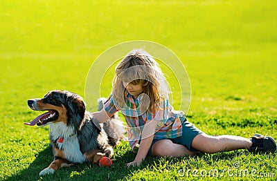 Little child boy with pet dog outdooors in park. Child with pet puppy dog. Stock Photo