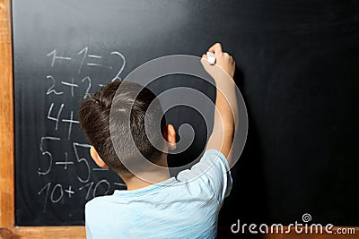 Little child with chalk doing math Stock Photo