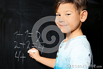 Little child with chalk doing math Stock Photo
