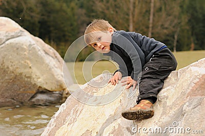 Little child climbing rock Stock Photo