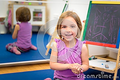 Little child is drawing with color chalk on the chalk board Stock Photo