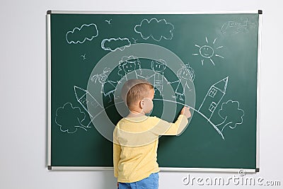 Little child drawing family with white chalk Stock Photo