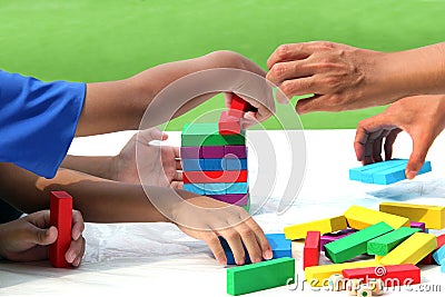 Little child and family playing wood colors block game in activity learning develop IQ of kids, wooden block toy for fun education Stock Photo