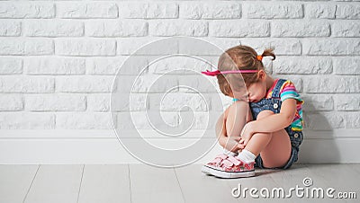 Little child girl crying and sad about brick wall Stock Photo