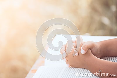 Little child girl hands folded in prayer on a Holy Bible Stock Photo