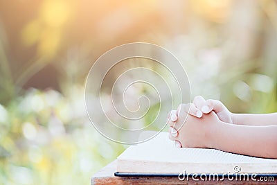 Little child girl hands folded in prayer on a Holy Bible Stock Photo