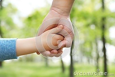 Little child holding hands with his father outdoors. Family time Stock Photo