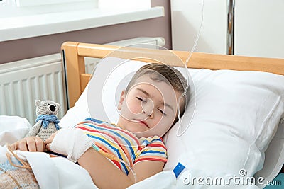 Little child with intravenous drip sleeping in hospital Stock Photo