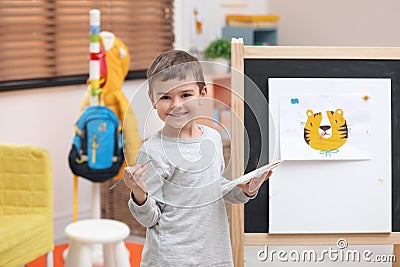 Little child painting on easel Stock Photo