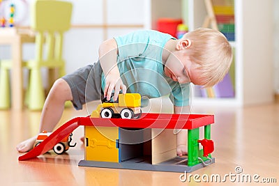 Little child playing with a toy car in nursery Stock Photo