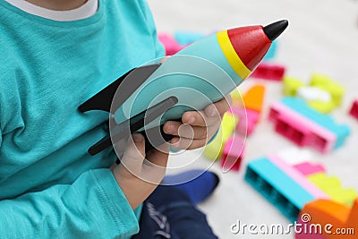 Little child playing with toy rocket indoors, closeup Stock Photo