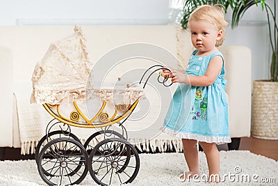 Little child is posing with small vintage pram Stock Photo