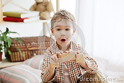 Little child sitting on the floor. Pretty boy palying with wooden cubes at home Stock Photo