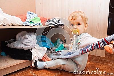 Little child throws clothes Stock Photo