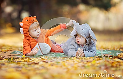 Little children in animal costumes playing in autumn forest Stock Photo