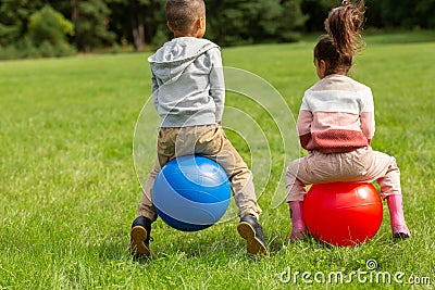 little children bouncing on hopper balls at park Stock Photo