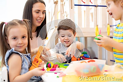 Little children engaged in playdough modeling at daycare Stock Photo