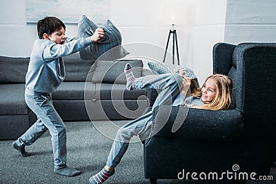 Little children in pajamas having pillow fight at home Stock Photo