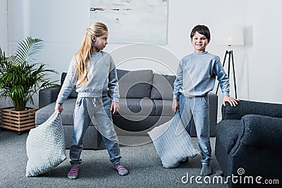 Little children in pajamas having pillow fight at home Stock Photo