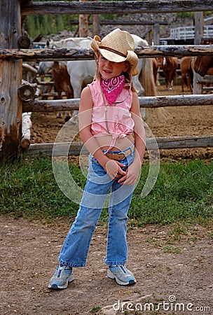 Little Cowgirl with Horse Corral Background Stock Photo