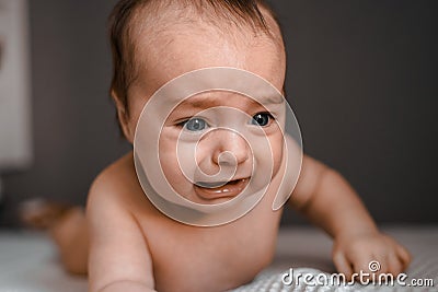 Little crying baby daughter on bed. One month age. Newborn cute happy beautiful girl smiling. Breast-feeding. Happiness Stock Photo