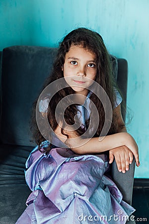 Little curly haired girl in purple dress Stock Photo