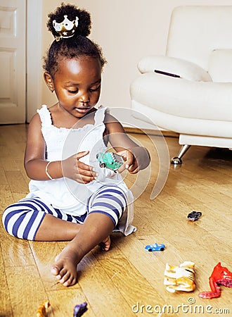 Little cute african american girl playing with animal toys at ho Stock Photo