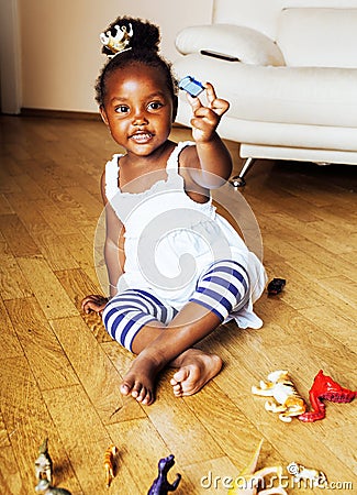 Little cute african american girl playing with animal toys at ho Stock Photo