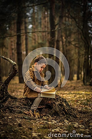 Little cute child is reading in the Forrest Stock Photo