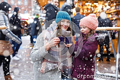 Little cute daughter and mother with cup of steaming hot chocolate or children punch Stock Photo
