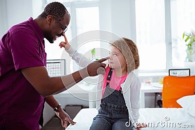 Little cute daughter visiting father at work touching his nose Stock Photo