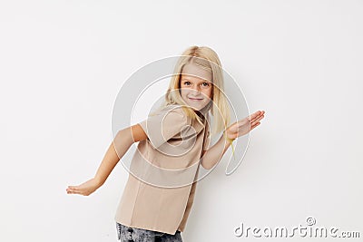 Little cute girl beige t-shirts grimace on a light background Stock Photo