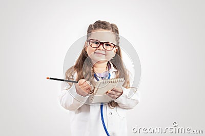 Little cute girl in doctor costume holding sthetoscope on chalkboard. Stock Photo