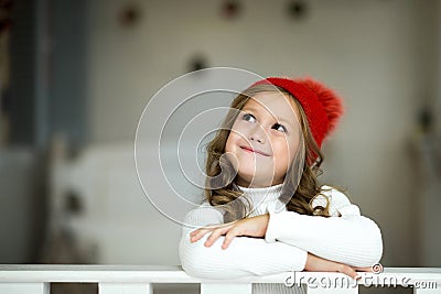 A little cute girl dreams of gifts. Girl making a wish. Merry Christmas and Happy Holidays Stock Photo