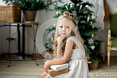 A little cute girl dreams of gifts. Girl making a wish. Merry Christmas and Happy Holidays Stock Photo