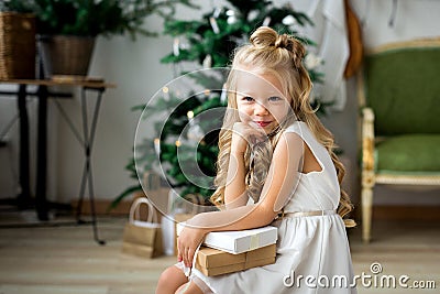 A little cute girl dreams of gifts. Girl making a wish. Merry Christmas and Happy Holidays Stock Photo