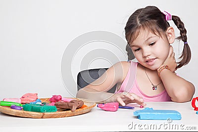 Little cute girl molds from clay mass Stock Photo