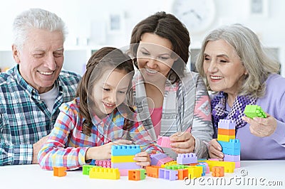 Little cute girl with mother and grandparents playing together Stock Photo