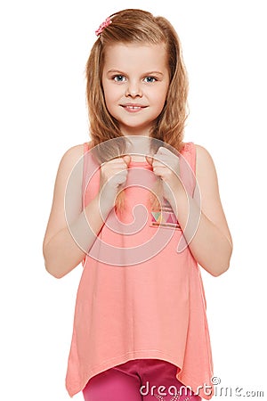 Little cute girl in a pink shirt holds hands hair, isolated on white background Stock Photo