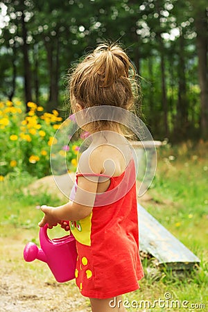 Little cute girl playing with plant watering can Stock Photo